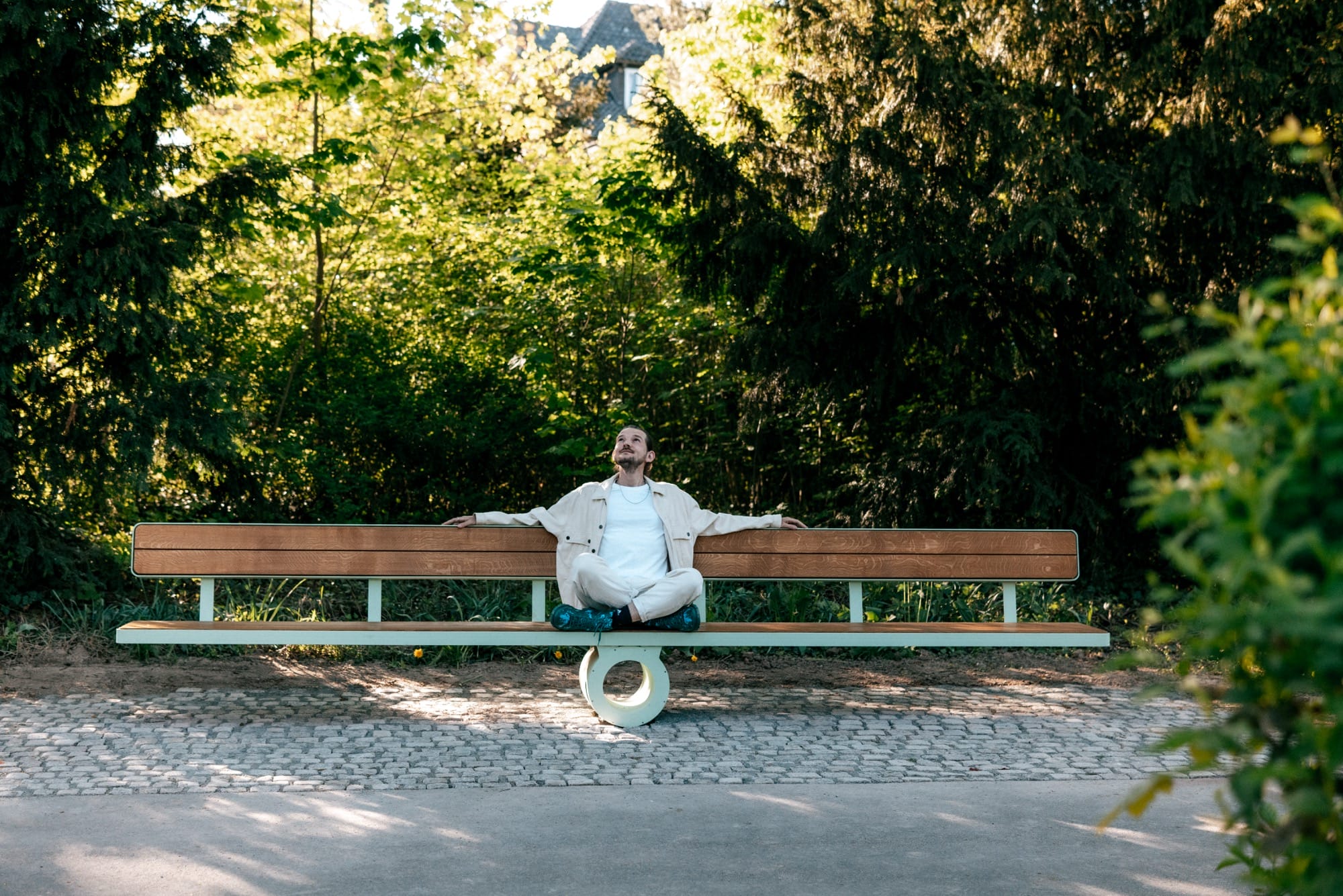 a white man sits in the middle of a bench to balance the weight