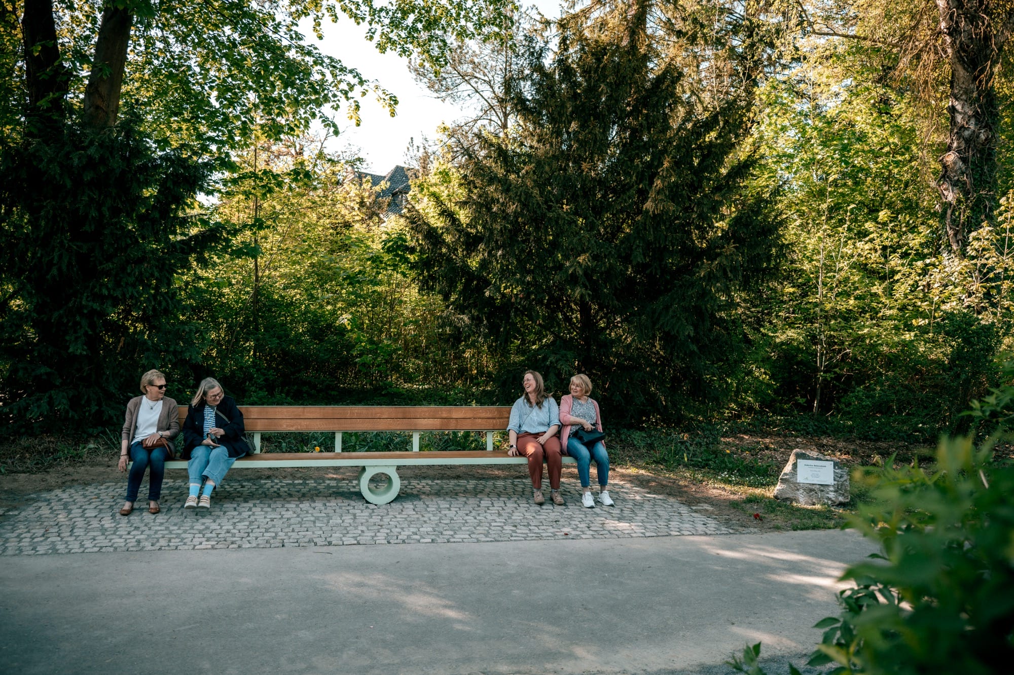 a bench sits perfectly flat  as people balance on either side
