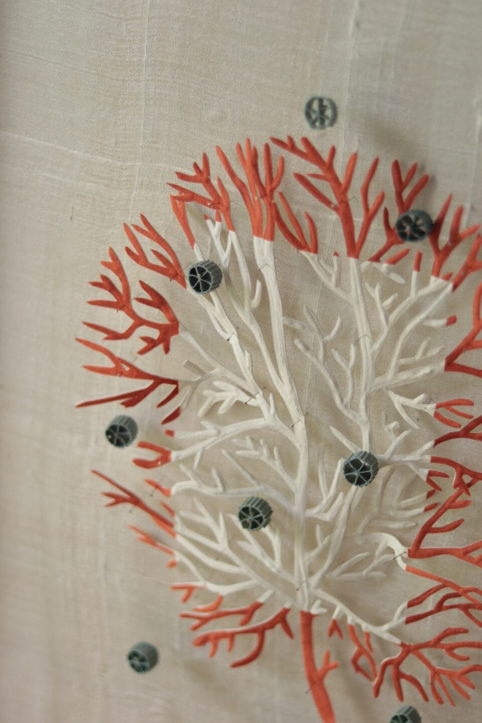 a detail of a framed artwork made of cut material in the shape of coral