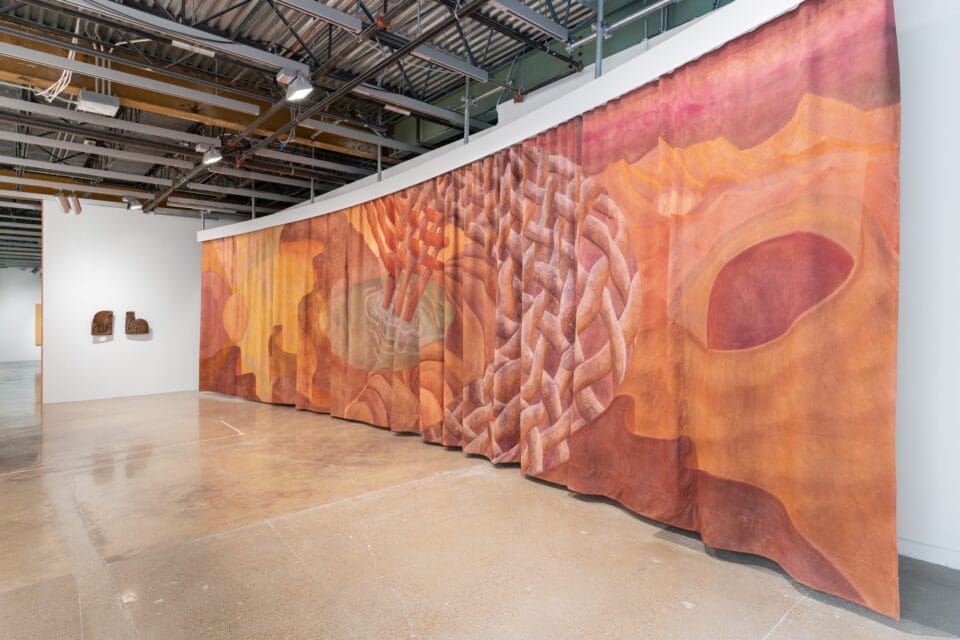 a long pink and orange hanging tapestry