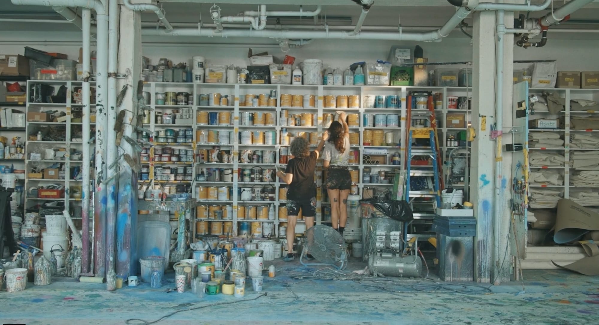 a still of a mother and daughter grabbing paint cans