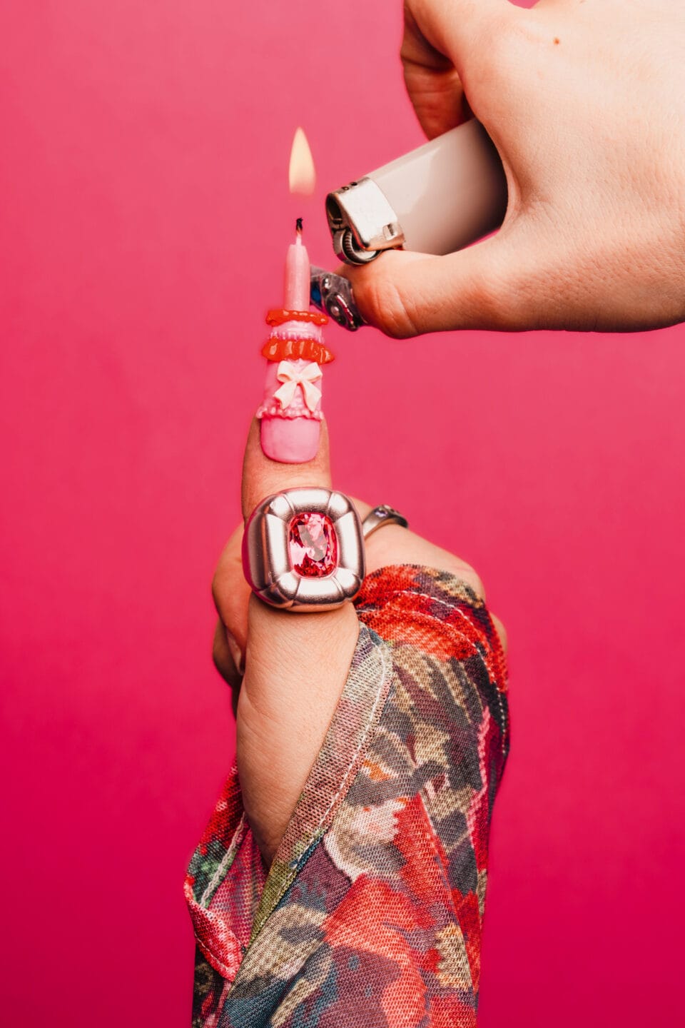 a thumb nail with an intricate pink and red birthday cake design being lit with a lighter