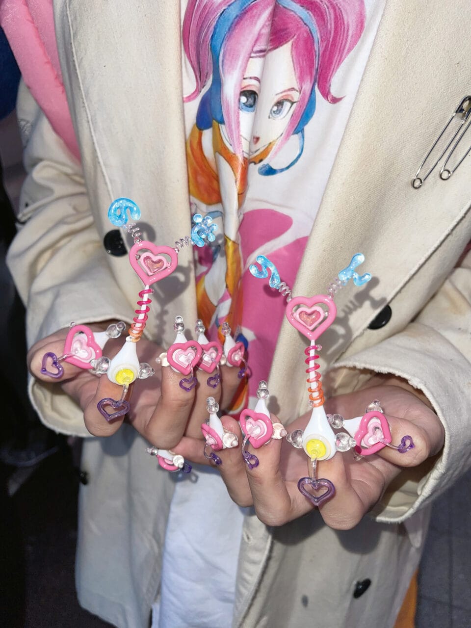a detailed manicure with 3 dimensional designs including spirals and protruding stalks with hearts