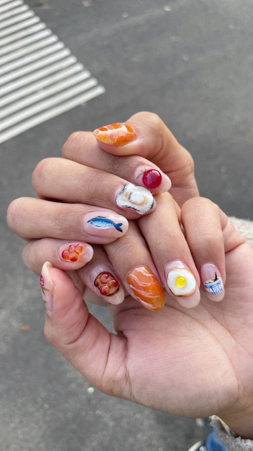 a short manicure with small paintings of fish, eggs, salmon, and roe
