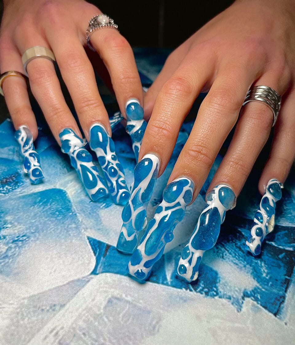 bulbous blue nail designs with white details, evoking water
