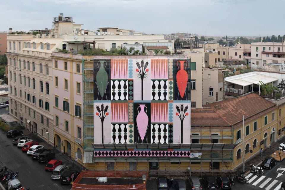 a large-scale printed covering for scaffolding with geometric shapes of amphorae and other patterns