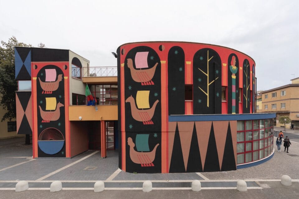 a large mural on a building with a curved facade, featuring geometric shapes and a series of Viking ships