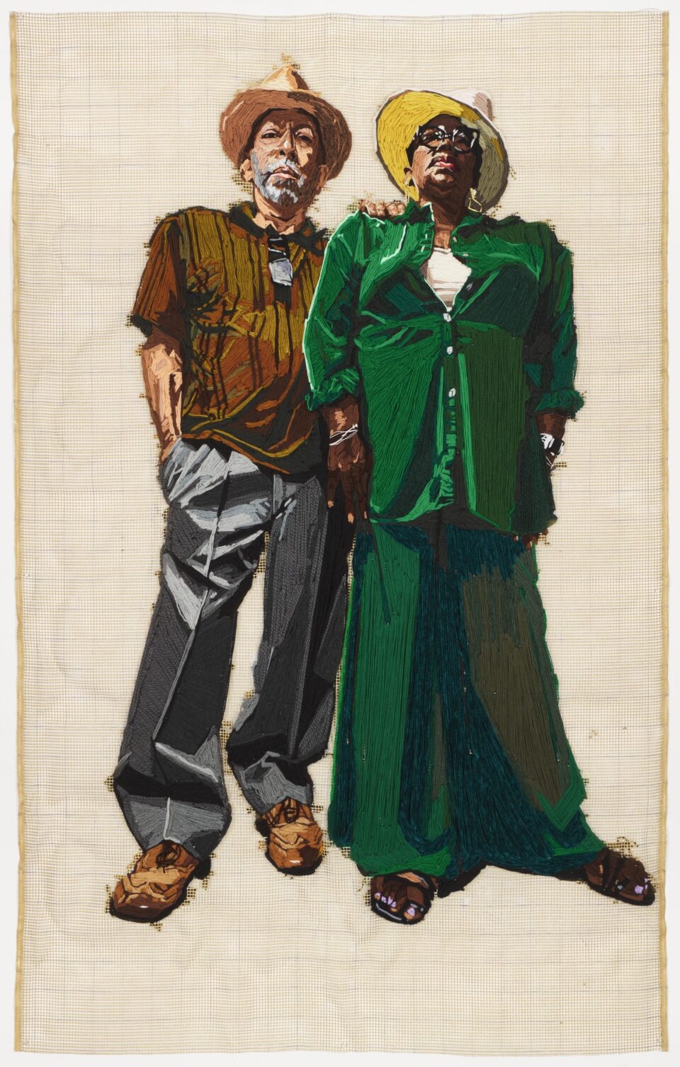 a large-scale embroidered portrait of two vibrantly-dressed Black figures against a yellow gridded background