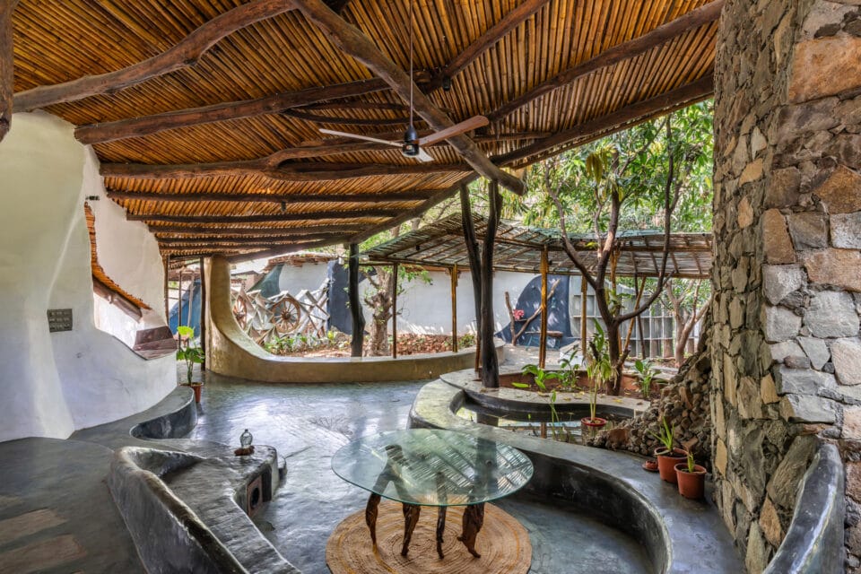 the interior of a biophilic residential design, with wood-beamed ceilings, organic walls, and earthy floors