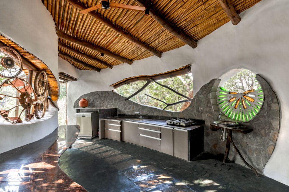 the interior of a biophilic residential design, with wood-beamed ceilings, organic walls, and earthy floors
