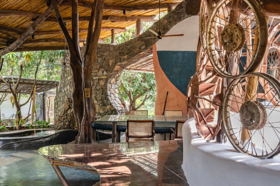 the interior of a biophilic residential design, with wood-beamed ceilings, organic walls, and earthy floors