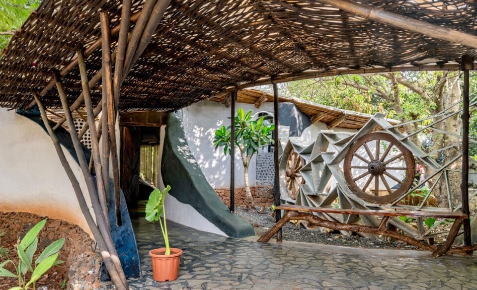 the interior of a biophilic residential design, with wood-beamed ceilings, organic walls, and earthy floors