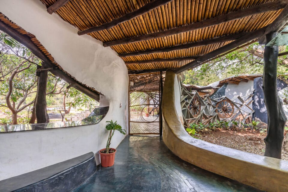 the interior of a biophilic residential design, with wood-beamed ceilings, organic walls, and earthy floors