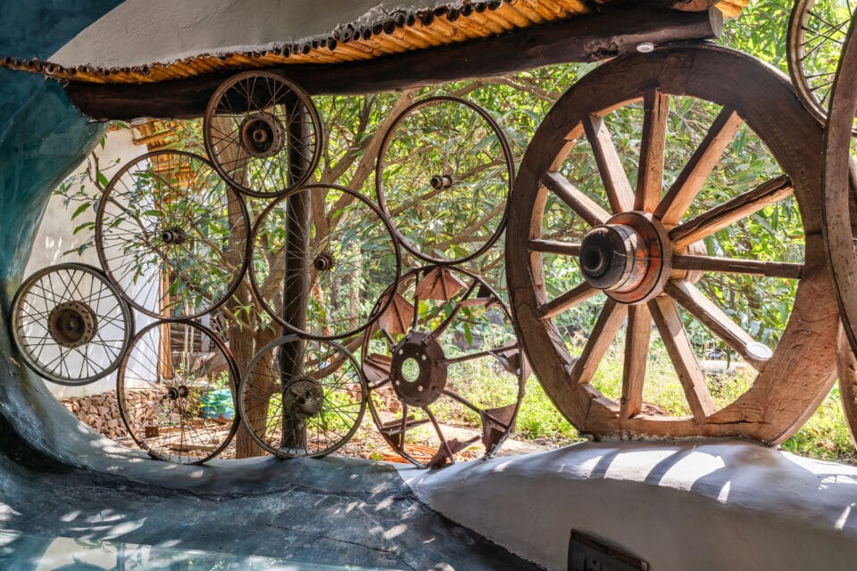 the interior of a biophilic residential design, with a wall made of repurposed wagon wheels
