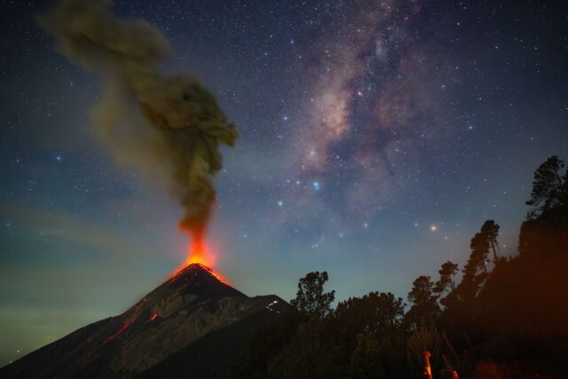 a volcano erupts beneath the milky way