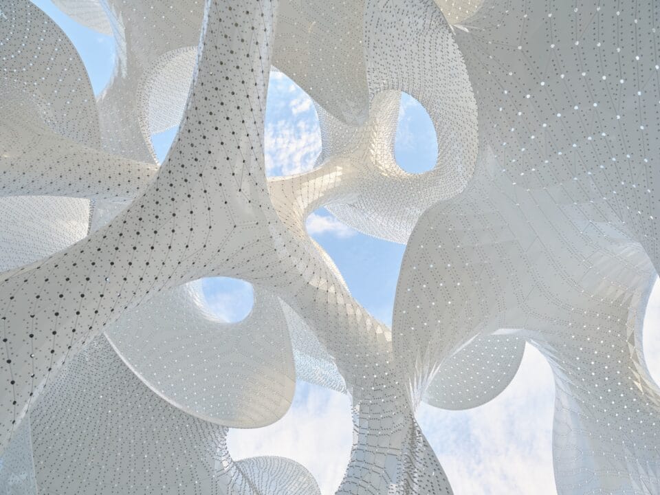 a detail of a contemporary white architectural pavilion with undulating forms in the overall shape of a sphere