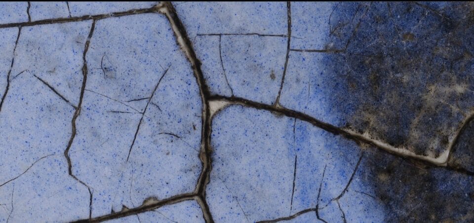 an extremely close-up detail of an oil painting with a blue, crackled texture