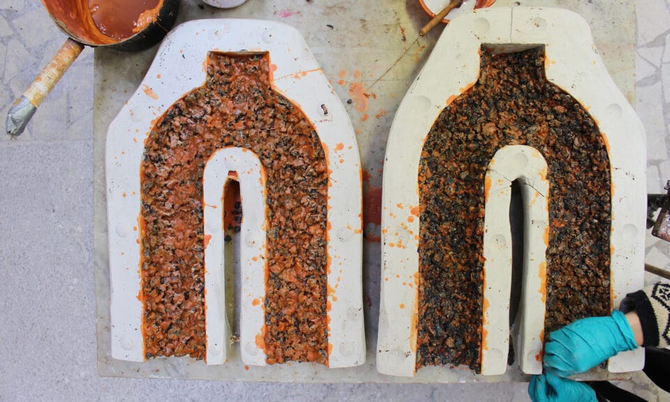 Two molds for U-shaped structure with orange wax and gravel.
