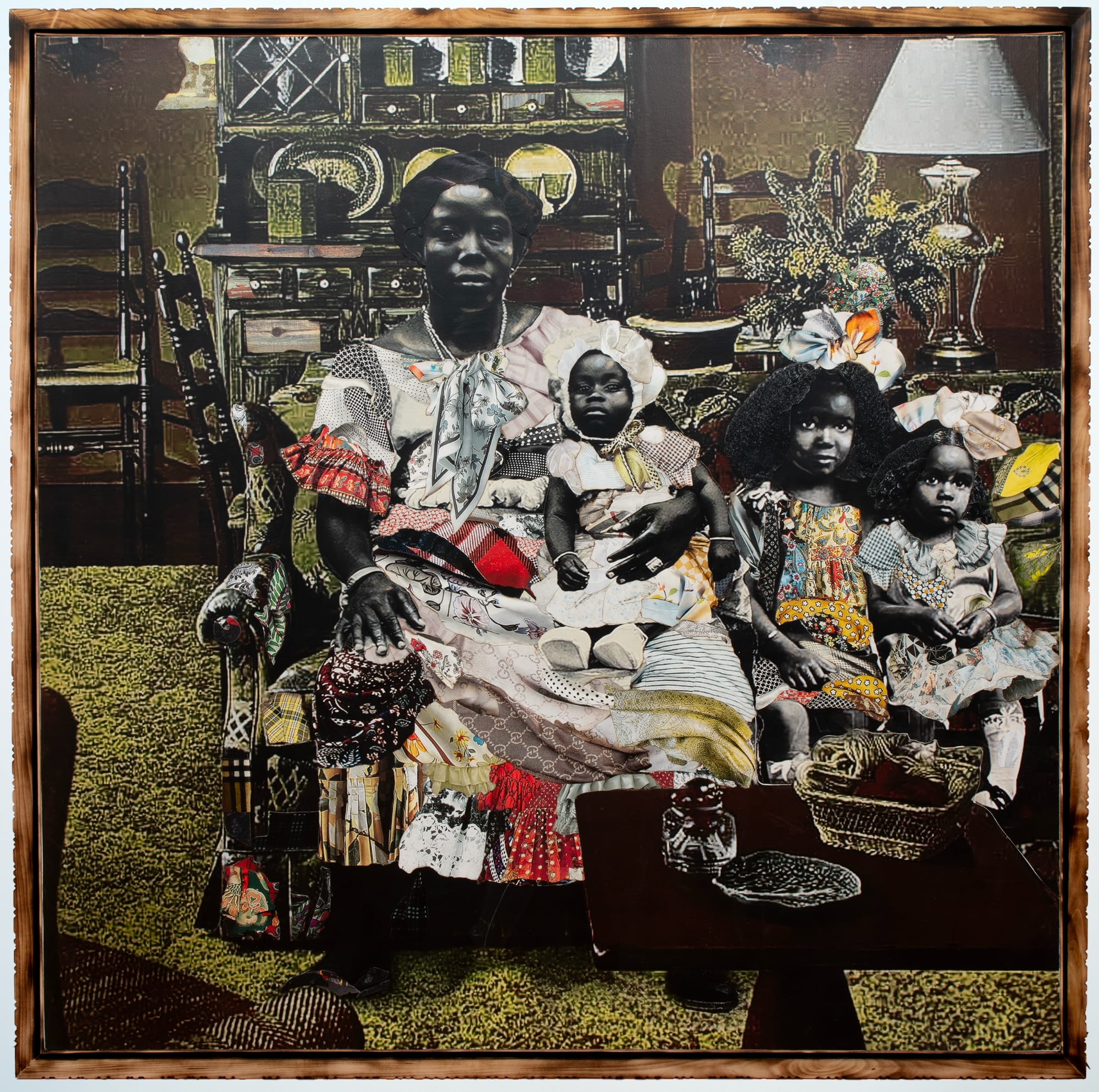 a collage of black and white photos and colorful textiles in a carved wooden frame. the photo depicts a mother and her childern
