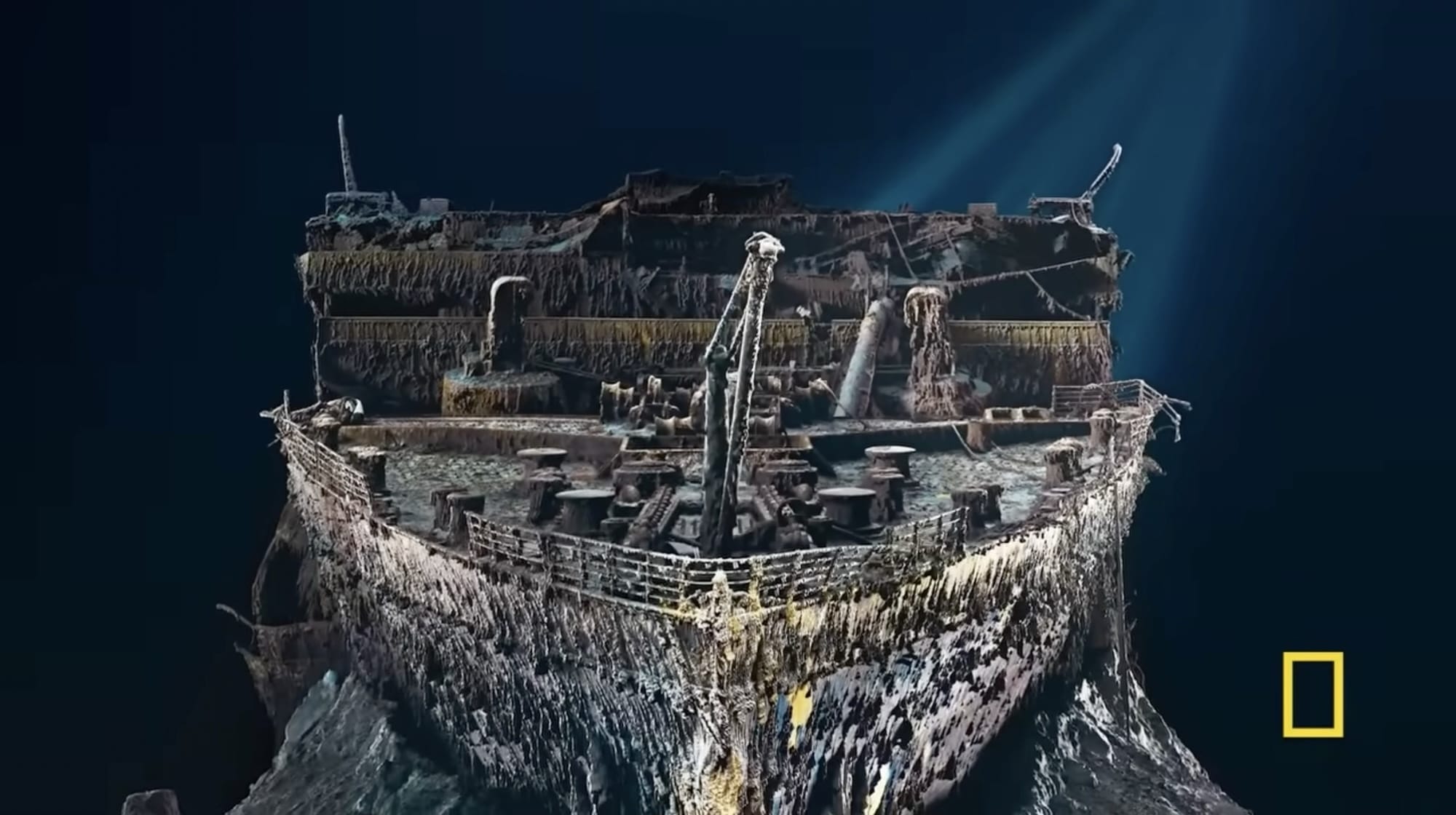 a still from a documentary about HMS Titanic, showing a large-scale digital rendering of the shipwreck on the ocean floor