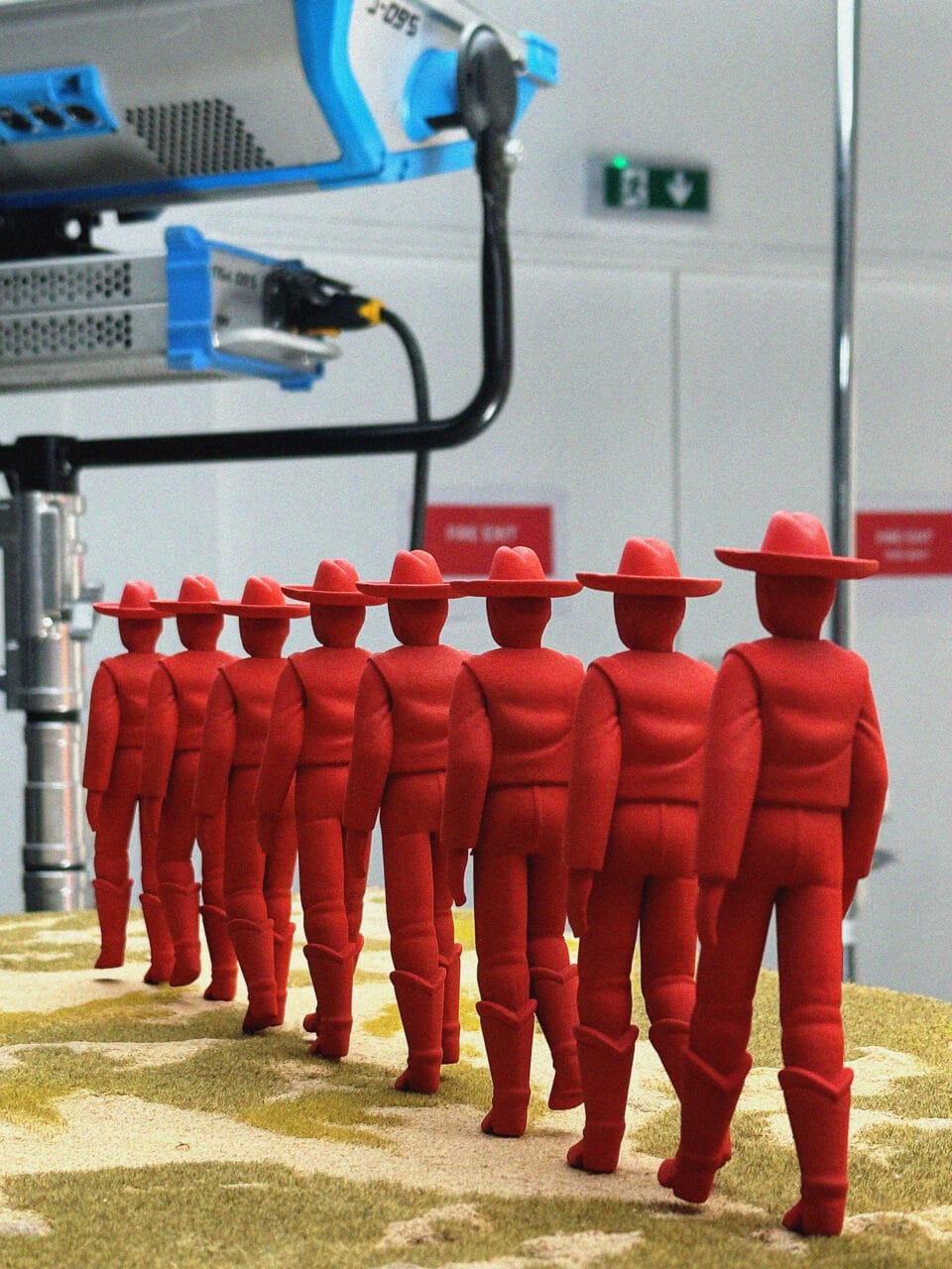 a behind the scenes image of several red cowboys at various stages of the walking process