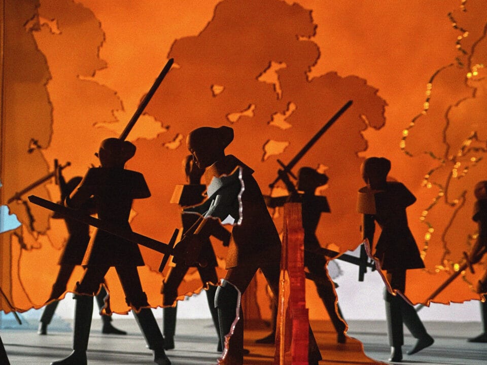 several women in armor with swords fight against an orange backdrop